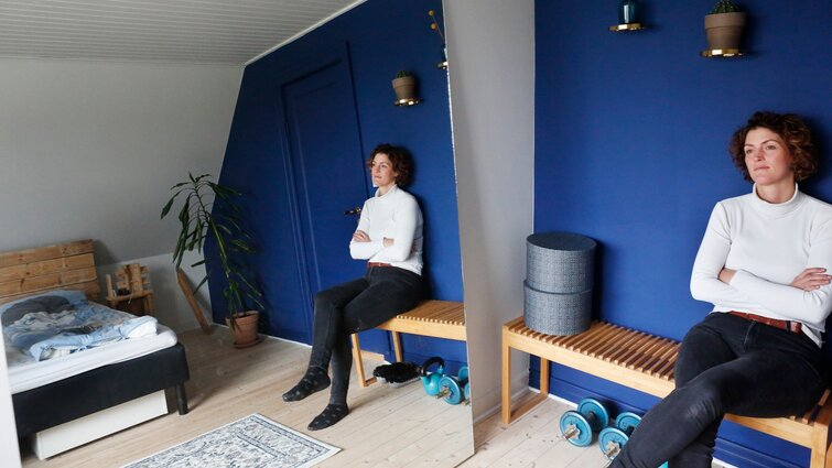 Lykke sidder på bænk i soveværelset