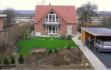Rødt parcelhus med forhave og carport