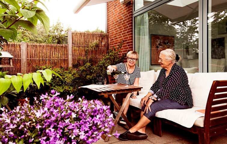Mor og datter sidder på en terrasse. Mor og datter sidder på en terrasse.