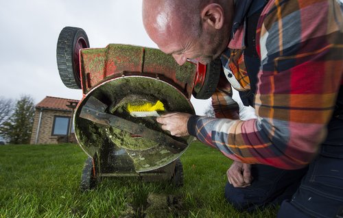 Gammelt græs og jordrester under plæneklipper fjernes