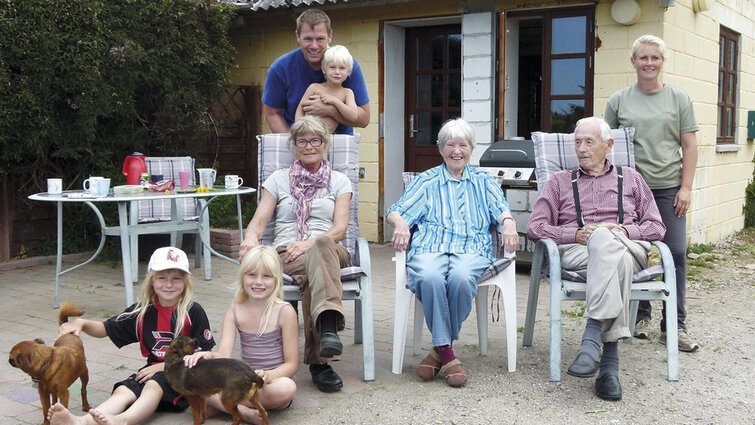 Familie i flere generationer foran hus