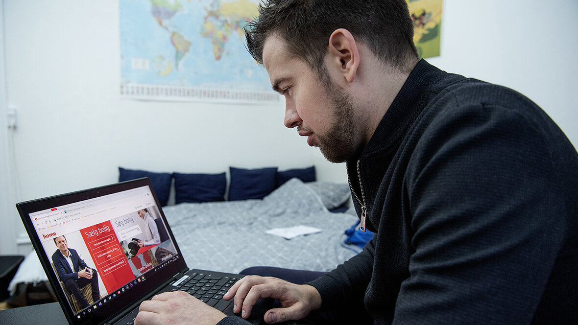 Mand sidder ved computer og kigger på boligside