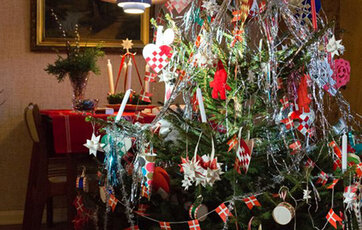 Pyntet juletræ med bl.a. Dannebrogsflag og en stjerne i toppen.