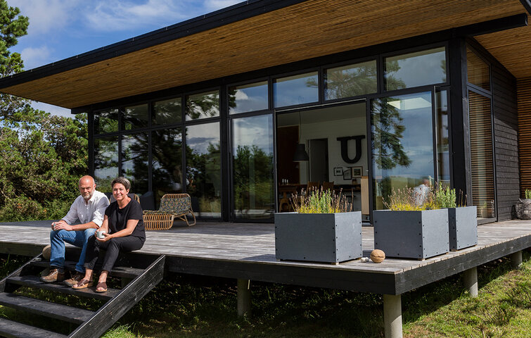 Peter Bigum og Lone Palshøj foran deres selvbyggede sommerhus med udsigt til Sejerø Bugt og Kattegat