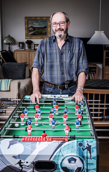 65-årige Niels Henriksen står i sin stue foran et nyt bordfodboldbord.