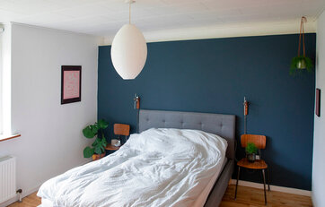 En væg er farvet i soveværelset i blå farve Deco Blue