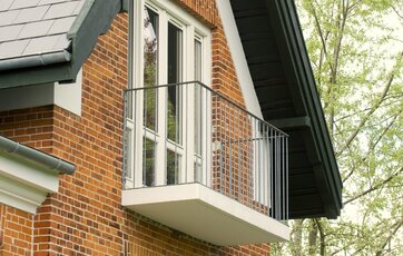 Ny altan på ældre villa. altan med en bund af beton og værn af galvaniseret stål. Arkivfoto.
