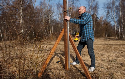 Flyt loddebrættet tjek af, at stolpen står i lod på den anden side af stolpen