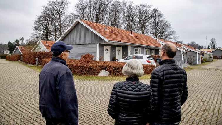 Tre beboere kigger på seniorbofællesskabet Florahøj