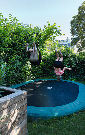 børn hopper på stor trampolin i haven