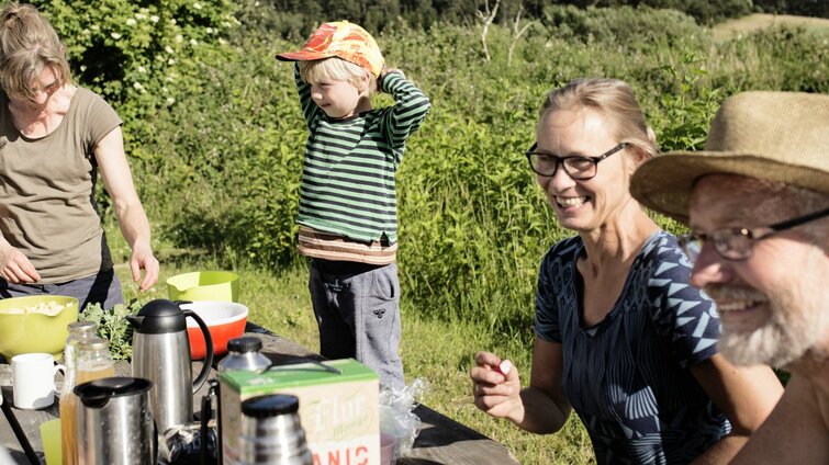 Familie spiser mad i grønne omgivelser