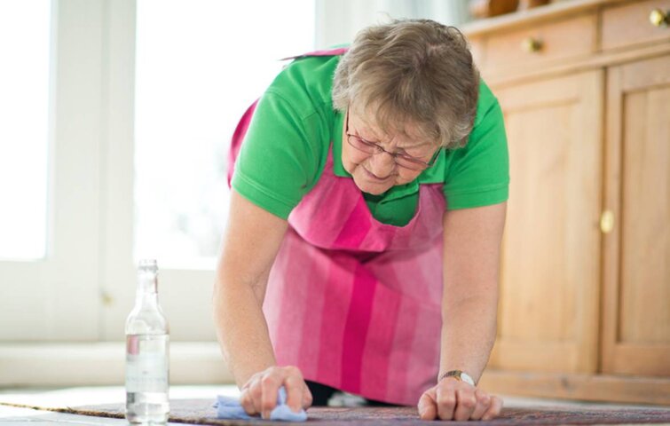 Oldfruen fjerner pletter fra tæppe med danskvand