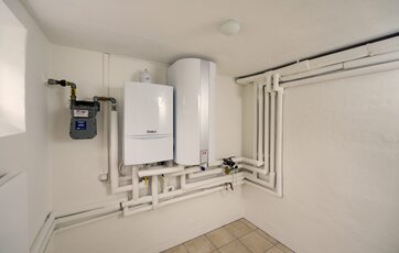 gasmåler, gasfyr og varmtvandsbeholder monteret på kældervæg
