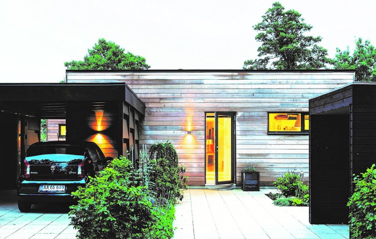 Bil holder i carport foran hus