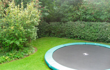 Trampolin gravet ned i græsplæne