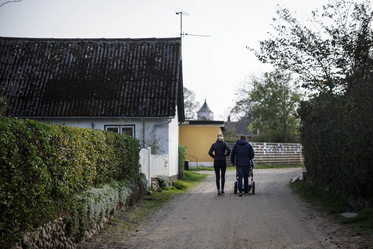 Par går tur med barnevogn på grusvej i Anholt by