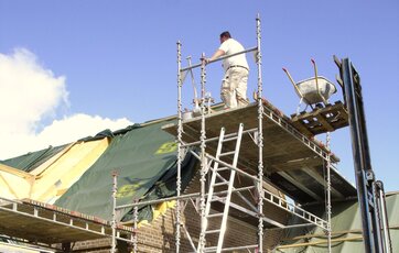 Murer arbejder på et stillads i 1. sals højde Murer arbejder på et stillads i 1. sals højde