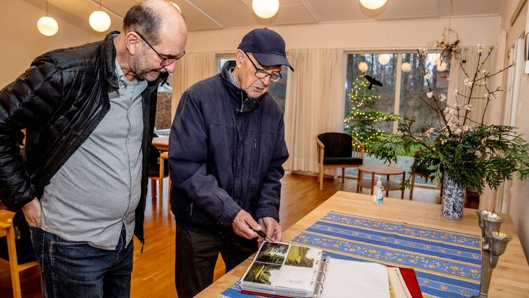 To mænd kigger i fotoalbum