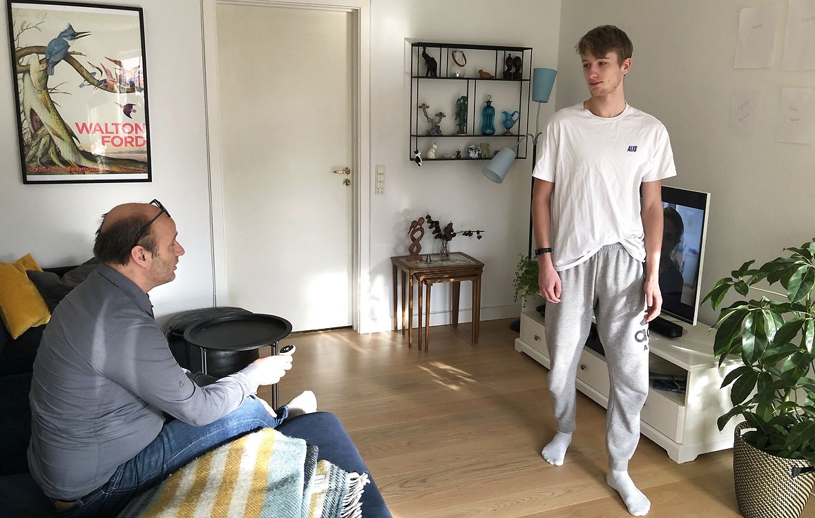 Ung mand går ind foran, mens far ser tv