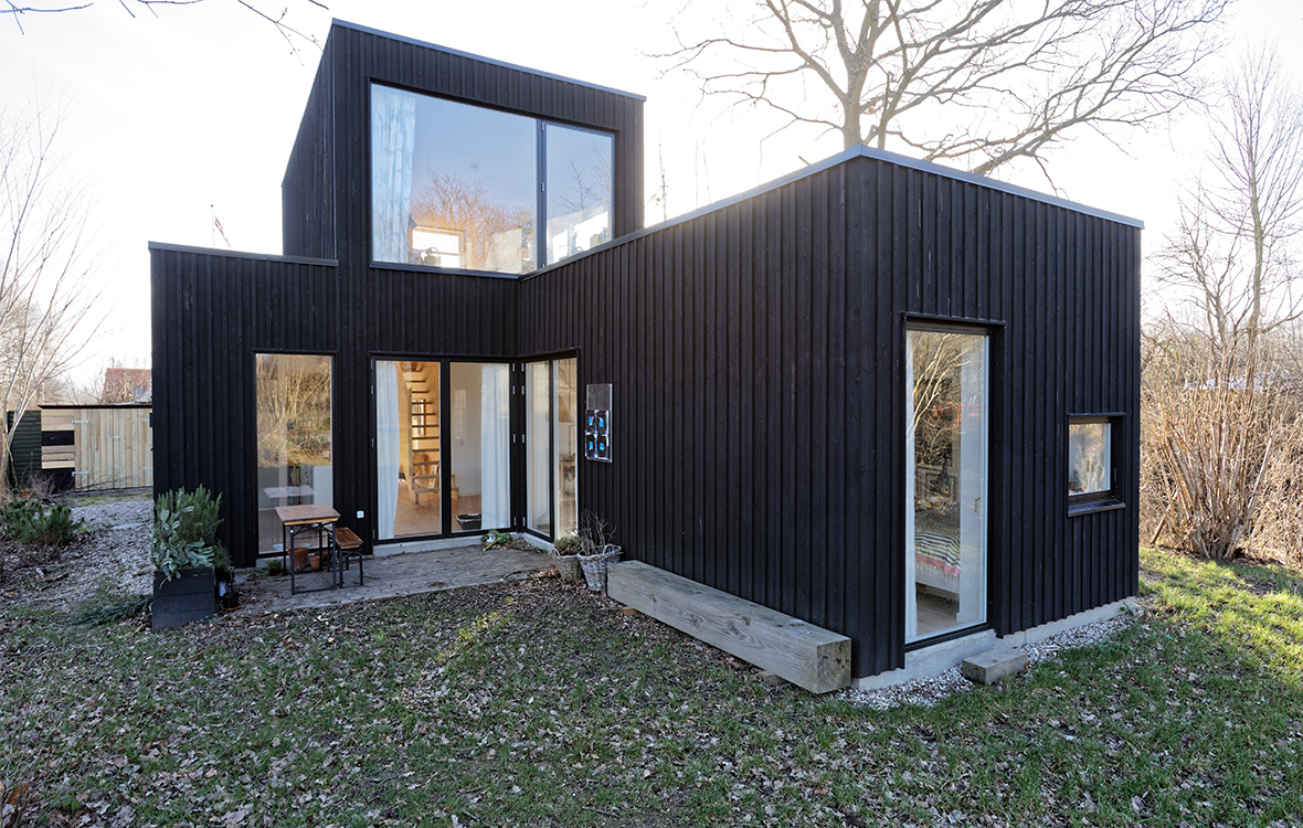 Nybygget træhus i moderne arkitektur gemt bag gamle træer