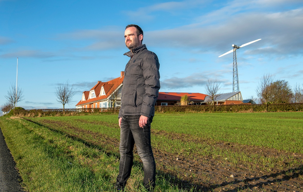 Mark Steiniche foran sit hus med vindmølle